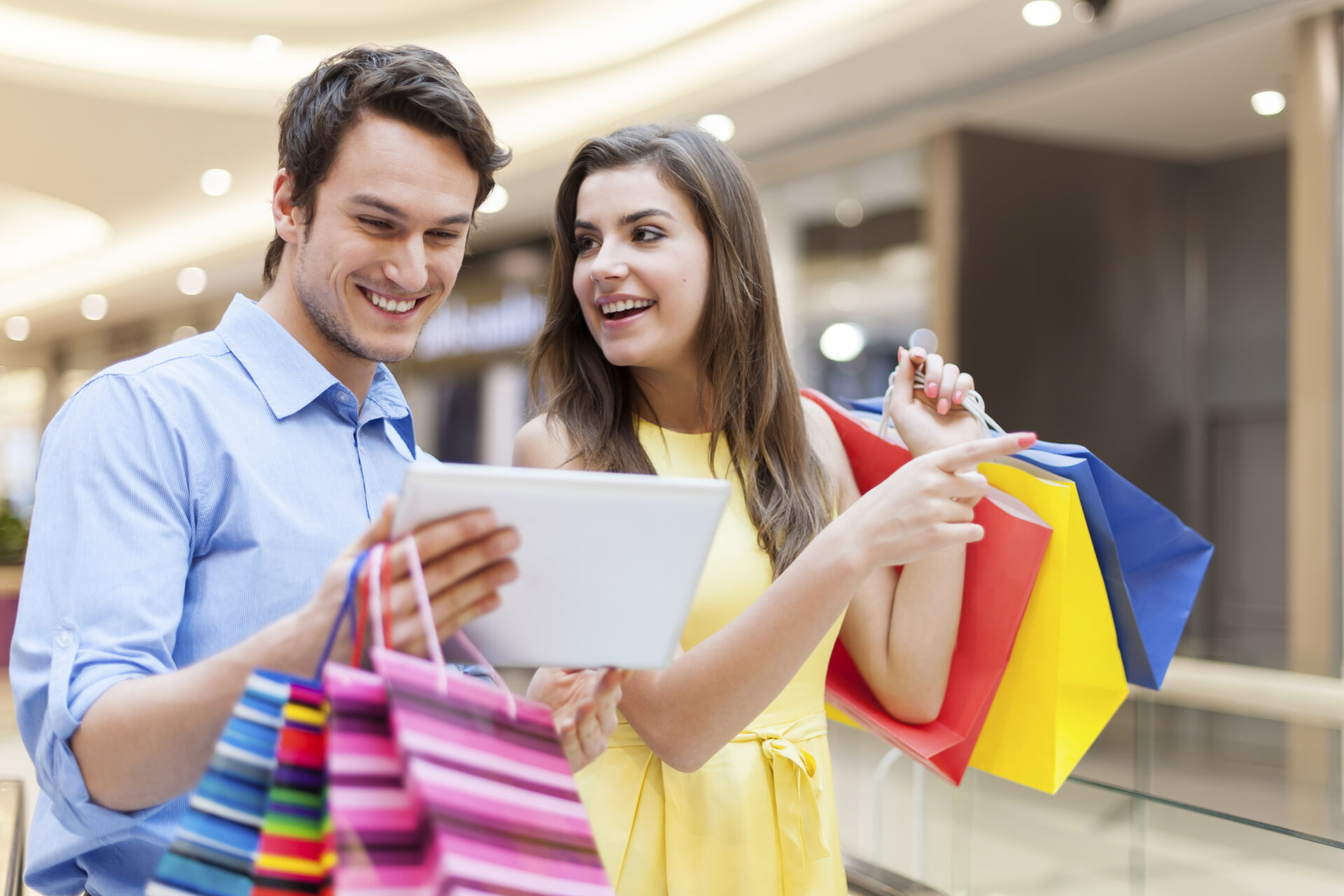 happy couple using digital tablet during shopping scaled